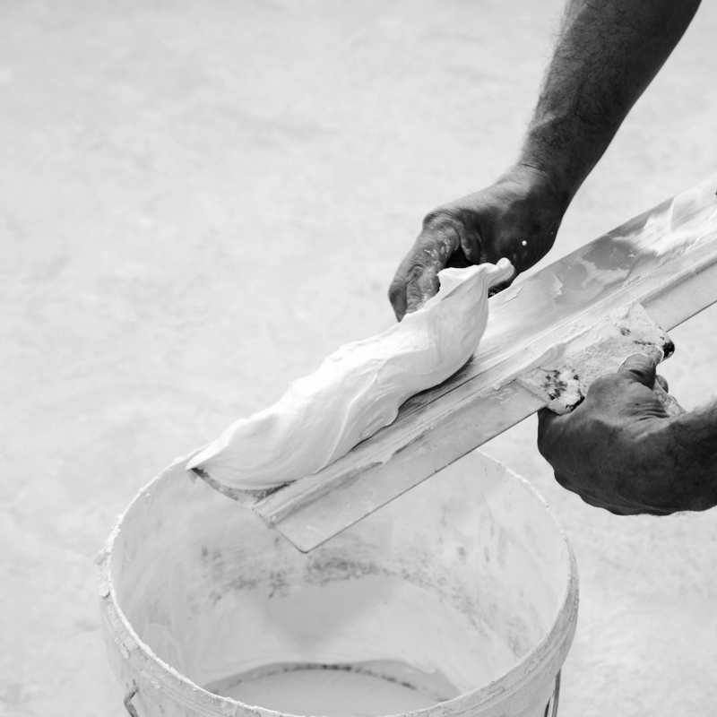 Professionel appliquant du béton ciré sur le sol